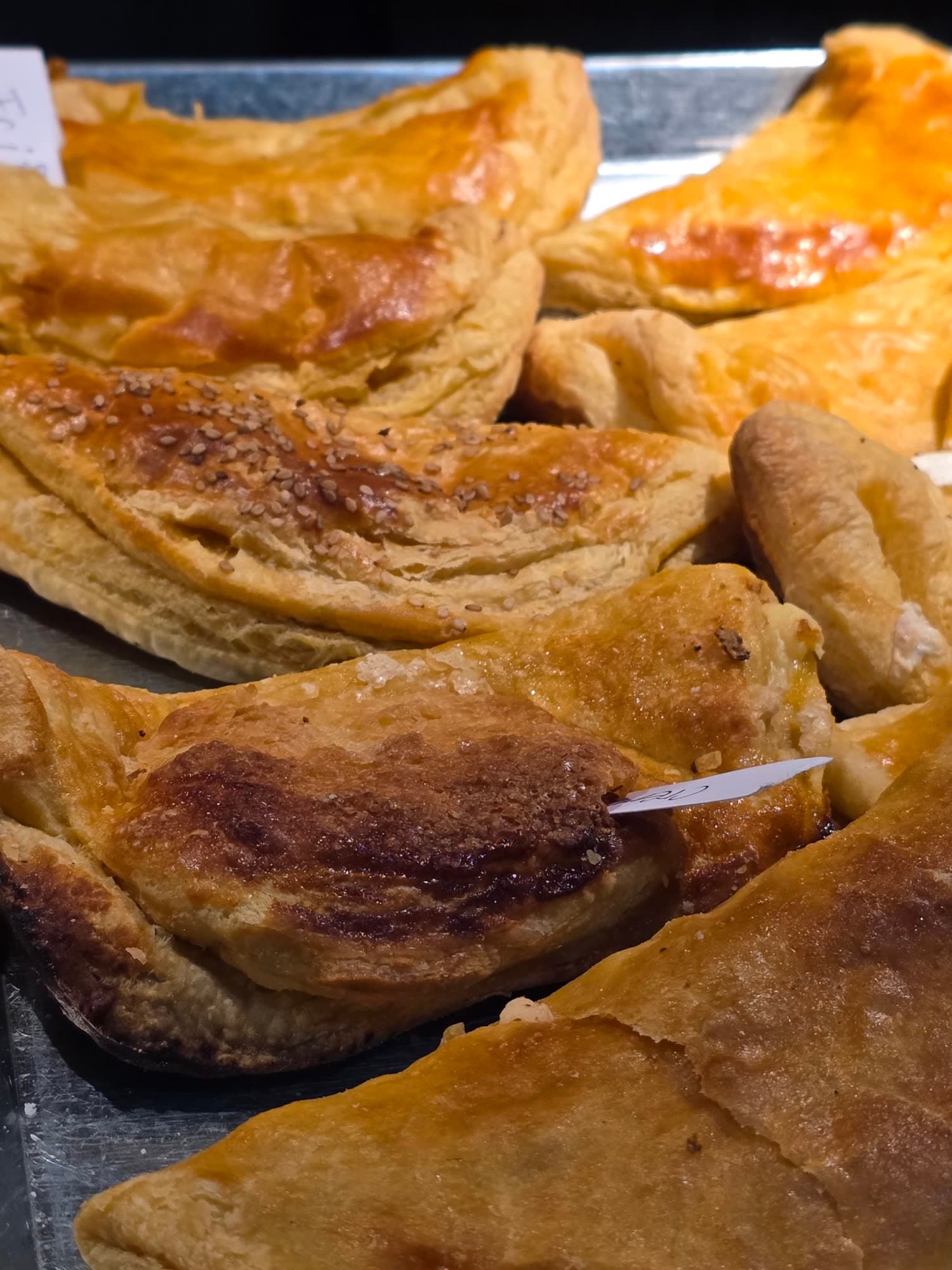 Pastes dorados acomodados en una charola de panadería